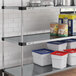 A Regency galvanized metal shelf with food containers and cans on it.