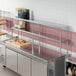 A stainless steel double deck overshelf on a counter in a kitchen.