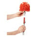 A long reach dusting kit with an extendable handle and a detachable orange duster head.