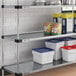 A Regency galvanized steel shelf with containers and cans on it.