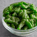 A bowl of green Albanese Gummi Army Guys on a counter.