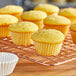 A close up of a yellow cupcake in a Wilton white mini baking cup.