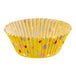 A yellow Wilton baking cup with colorful polka dots.