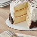 A cake on a Wilton white cake circle with a slice cut out.