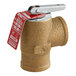 A close-up of a Watts bronze boiler pressure relief valve with a red tag.