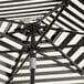 A black and white striped Lancaster Table & Seating umbrella with a black aluminum pole.