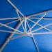 A close up of a blue Lancaster Table & Seating cantilever umbrella with silver metal rods.