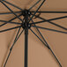 A close up of a black Lancaster Table & Seating umbrella with a brown base.