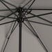 A Lancaster Table & Seating pewter gray umbrella with a black metal pole.