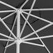 A close up of a black Lancaster Table & Seating round umbrella with a silver pole.