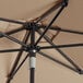 A Lancaster Table & Seating black aluminum umbrella with a wheat colored round canopy.