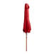 A Lancaster Table & Seating red umbrella on a woodgrain pole.