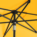 A close up of a Lancaster Table & Seating yellow umbrella with black poles.