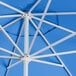 A close up of a blue Lancaster Table & Seating umbrella with a silver pole.