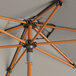 A close up of a Lancaster Table & Seating round woodgrain aluminum umbrella with a push lift.