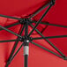 A red Lancaster Table & Seating umbrella with black metal poles.