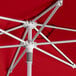 A red Lancaster Table & Seating umbrella with silver poles.