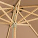 A Lancaster Table & Seating round mocha bamboo umbrella with a metal pole.