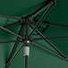 A Lancaster Table & Seating forest green umbrella with a black metal pole.