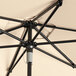 A close up of a Lancaster Table & Seating round sand umbrella with a black handle.