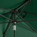 A Lancaster Table & Seating round forest green umbrella with black metal pole.