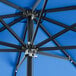 A close up of a Lancaster Table & Seating cobalt blue umbrella with metal poles.