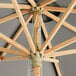 A Lancaster Table & Seating round wooden umbrella with a pulley lift mechanism.