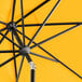 A close up of a Lancaster Table & Seating round yellow and black umbrella.