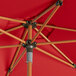 A red woodgrain Lancaster Table & Seating aluminum umbrella with wooden poles.