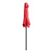 A close up of a red Lancaster Table & Seating umbrella with a black pole.