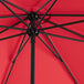 A Lancaster Table & Seating black steel umbrella with a red canopy.