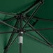 A Lancaster Table & Seating forest green umbrella with a black metal pole.