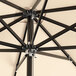 A close up of a Lancaster Table & Seating black and tan square umbrella with a pulley lift.