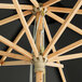 A Lancaster Table & Seating black bamboo umbrella with a pulley lift.