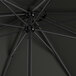 A black Lancaster Table & Seating umbrella with metal rods.