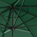 A Lancaster Table & Seating forest green umbrella with black metal poles.