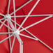 A close up of a red Lancaster Table & Seating umbrella with a silver pole.