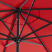 A close up of a Lancaster Table & Seating red umbrella with black metal poles.