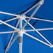 A Lancaster Table & Seating cobalt blue umbrella with white poles.