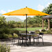 A Lancaster Table & Seating yellow umbrella on a black outdoor patio table.