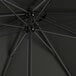 A black Lancaster Table & Seating umbrella with metal rods.