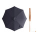 A Lancaster Table & Seating indigo blue bamboo umbrella with a wooden pole.