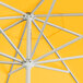 A close up of a yellow Lancaster Table & Seating umbrella with silver poles.