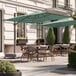 A patio with tables and a Lancaster Table & Seating cantilever umbrella.