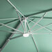 A close up of a Lancaster Table & Seating square green umbrella with a light fixture on the frame.