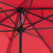 A close up of a Lancaster Table & Seating round strawberry umbrella with black poles.