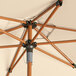 A close up of a Lancaster Table & Seating woodgrain umbrella with a sand pole.