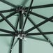 A close up of a black aluminum Lancaster Table & Seating umbrella with metal poles.