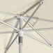 A Lancaster Table & Seating ivory umbrella with a silver metal pole.