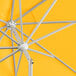 A close up of a yellow Lancaster Table & Seating umbrella with a silver pole.